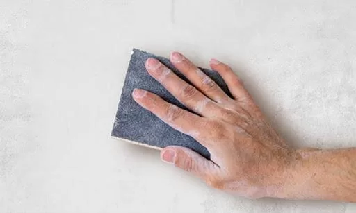Dùng giấy nhám để loại bỏ các điểm gồ ghề